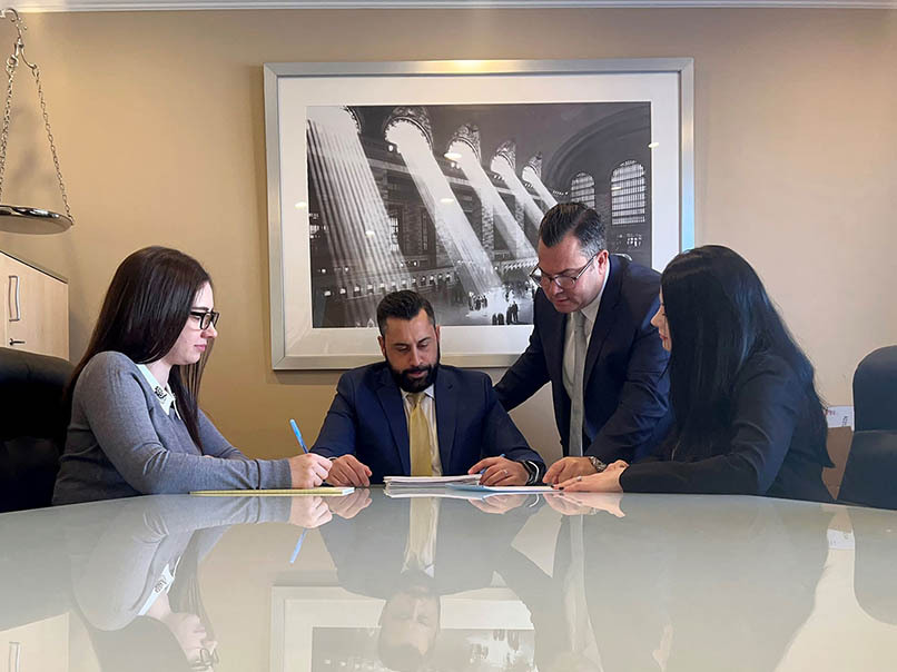 Attorney and clients discussing wills and estate planning documents in legal office.